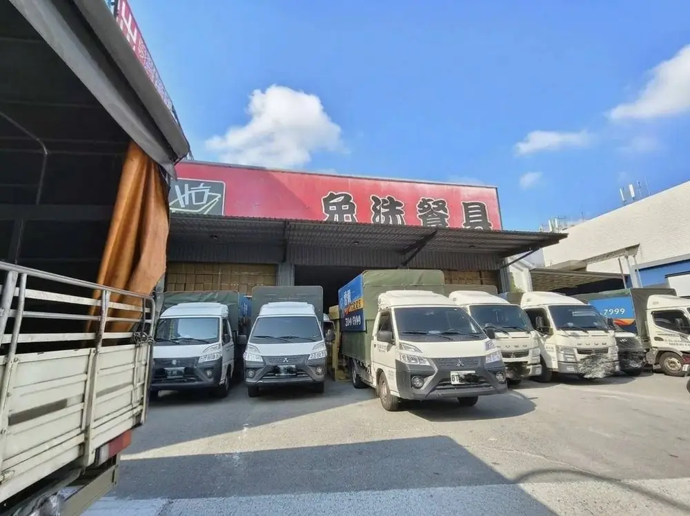 紅色「免洗餐具」招牌的門市,門口停著多台貨車